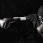A black and white photo of a boxer punching